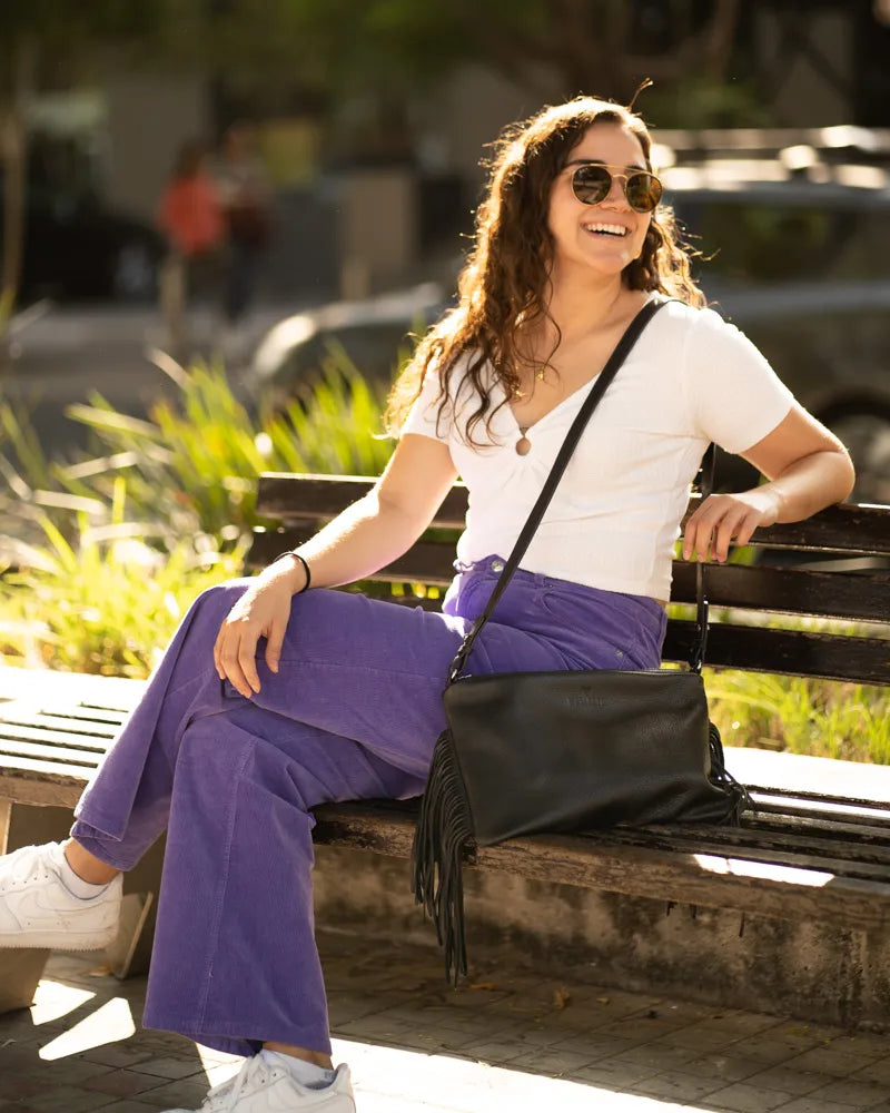 A lady resting in the park with him crossbody bag